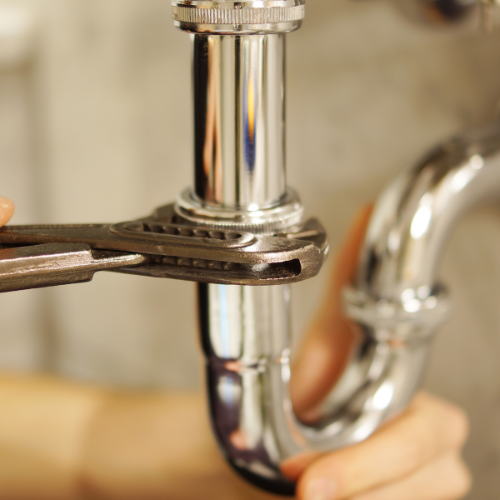 A wrench tightening a pipe.